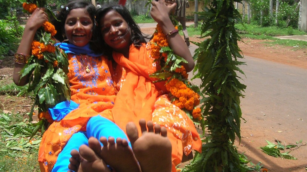 Women enjoying a Raja festival swing during Odisha celebrations